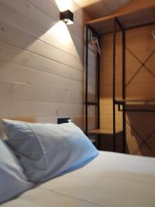 Dormitorio con cama con almohada y lámpara en Algar Carnota, en Carnota