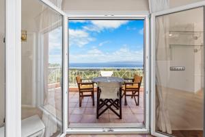 a room with a balcony with a table and chairs at Villa Erato in Tsoukalades