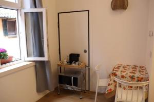een kleine kamer met een tafel en een spiegel bij Little apartment over the canal in Bologna
