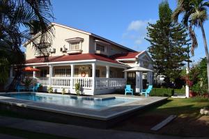 ein Haus mit einem Pool vor einem Haus in der Unterkunft Hostal Marlyn in San Andrés