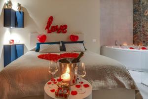 a bedroom with a bed with two glasses and a tub at !!! IDROMASSAGGIO !!! - Love Suite in Sciacca