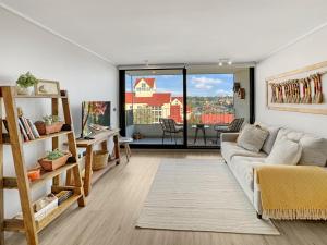 a living room with a couch and a large window at La mejor ubicación y nuestro servicio 5 estrellas in Puerto Varas