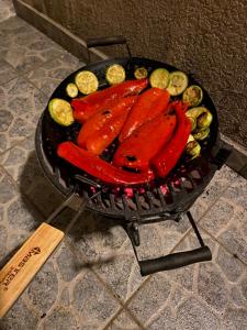 a grill with hot dogs and vegetables on it at Apartments Arina in Krasici