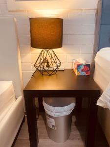 a table with a lamp and a trash can at YnY Guest house in Waterford