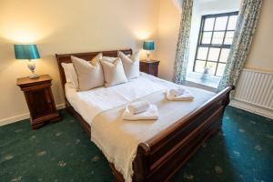a bedroom with a large bed with towels on it at Glasfryn Fawr in Pwllheli