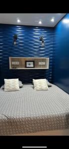 1 dormitorio con 1 cama grande y pared azul en Chambre Love Luxe Monaco, en Beausoleil