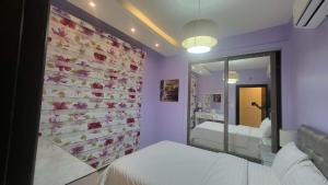 ein Schlafzimmer mit einem Bett und einer Wand mit Blumen in der Unterkunft Western Gate Residence 2 Amman in Amman