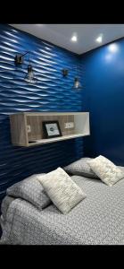 ein Schlafzimmer mit einer blauen Wand und einem Bett in der Unterkunft Chambre Love Luxe Monaco in Beausoleil