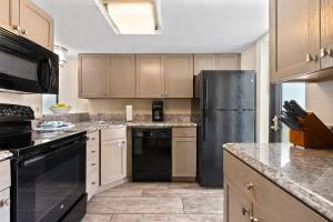 a kitchen with a black refrigerator and cabinets at Club Wyndham Westwinds in Myrtle Beach