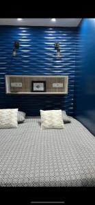 Chambre Love Luxe Monaco في بوسولاي: غرفة نوم بسرير كبير بجدار ازرق