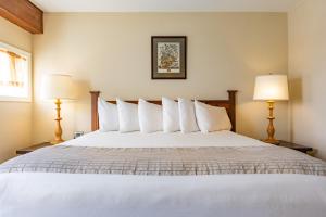 a bedroom with a large white bed with two lamps at Wolfeboro Inn in Wolfeboro