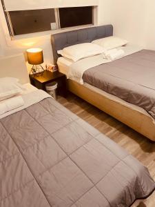 1 dormitorio con 2 camas, lámpara y ventana en YnY Guest house en Waterford