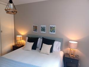 a bedroom with a bed with pillows and two lamps at Chic Benalmadena in Benalmádena