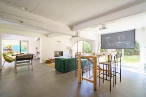 ein Wohnzimmer mit einem TV, einem Tisch und Stühlen in der Unterkunft La Conciergerie Biarritz in Biarritz