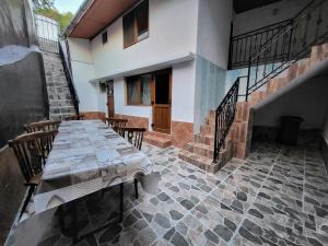 a patio with a table and chairs in a house at Casă de vacanță Danube in Moldova Nouă