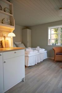 Habitación con cama con sábanas blancas y ventana. en Hotel Kysten en Hasle