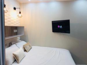 Chambre Love Luxe Monaco في بوسولاي: غرفة نوم مع سرير وتلفزيون على الحائط