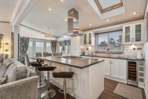 a kitchen with a large island in a living room at Cormorant - Luxury Lodge Close to the Beach in Tenby
