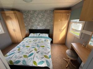a small bedroom with a bed and a desk at Sealands 29 - Ingoldmells, pet friendly, bed linen & close to fantasy island - Meadow Lakes Caravan & Lodge Hire in Ingoldmells