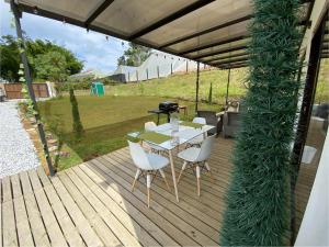 une terrasse en bois avec une table, des chaises et un grill dans l'établissement Casa campestre descanso relajación jacuzzi BBQ amplias zonas verdes, à Carmen de Viboral