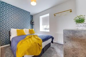 a bedroom with a bed with a yellow blanket at Immaculate Ground Floor Flat - Families in Sheffield