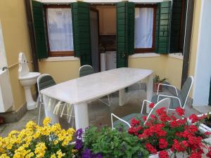un tavolo con sedie e fiori di fronte a un edificio di NIDO TRA LE MURA a Montagnana