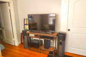 a flat screen tv sitting on a stand in a room at Urban Retreat on Flint in Jonesboro