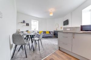 a kitchen and living room with a table and chairs at Immaculate Ground Floor Flat - Families in Sheffield