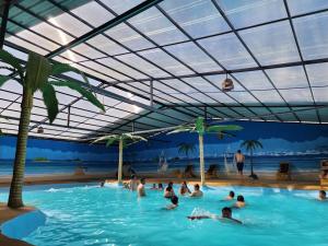 a group of people in a swimming pool at a beach at Hotel Pueblo del mundo in Baños