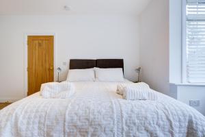 uma cama branca com duas almofadas em cima em Spacious Bedroom Ensuite in Brentwood Free Parking - Room 1 em Brentwood