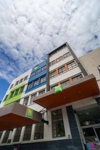 a tall building with colorful windows and a cloudy sky at Ibis Styles Invercargill in Invercargill