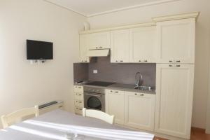a kitchen with white cabinets and a sink and a stove at Villa delle Rose in Portogruaro