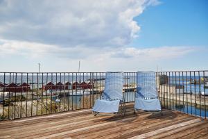 two blue chairs sitting on a balcony overlooking a marina at Hotel Kysten in Hasle