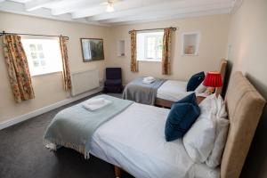 a bedroom with two beds and a red lamp at Rose Cottage in Pwllheli +20 photos