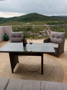 a table with two glasses of wine on a balcony at Studio apartman Bel Vedere in Motovun
