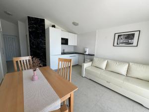 salon ze stołem i kanapą w obiekcie Mirakul Apartments w mieście Vir