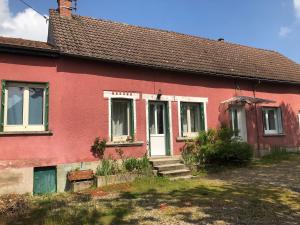 a red house with a white door and windows at La Maison Rose in Viévy