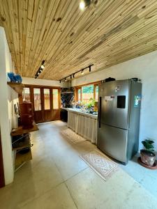 a kitchen with a stainless steel refrigerator and wooden ceilings at Casa Tuco - Cumuruxatiba in Cumuruxatiba