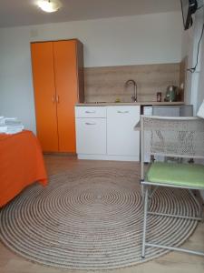 a kitchen with a table and a kitchen with orange cabinets at Studio apartman Bel Vedere in Motovun