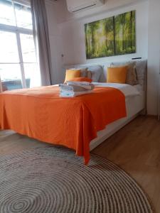 a bedroom with a large bed with an orange blanket at Studio apartman Bel Vedere in Motovun