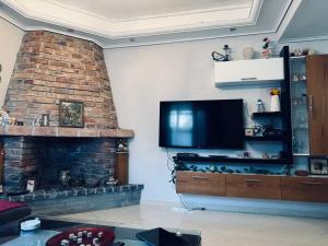 een woonkamer met een open haard en een flatscreen-tv bij Naldo Apartment in Xarrë