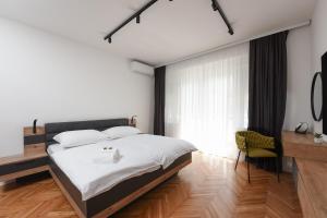 a bedroom with a large bed and a desk at Apartment Monika in Zadar