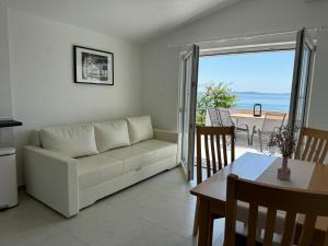salon z białą kanapą i stołem w obiekcie Mirakul Apartments w mieście Vir
