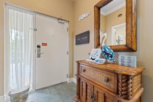 a bathroom with a mirror and a wooden dresser at Phoenix On The Bay 1108 by Vacation Homes Collection in Orange Beach