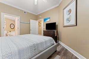 a bedroom with a bed and a flat screen tv at Phoenix On The Bay 1108 by Vacation Homes Collection in Orange Beach