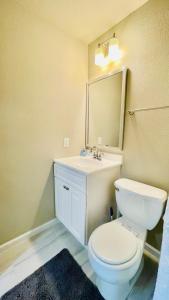 a bathroom with a toilet and a sink and a mirror at Cozy location in Midtown! in Houston