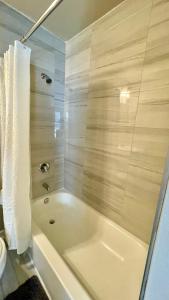 uma banheira branca na casa de banho com uma toalha em Cozy location in Midtown! em Houston