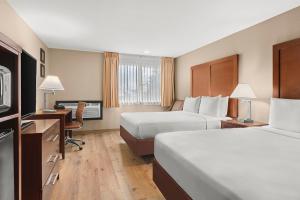 una camera d'albergo con 2 letti e una scrivania di Comfort Inn & Suites Beaverton - Portland West a Beaverton