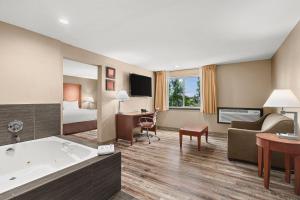 a hotel room with a bed and a tub at Comfort Inn & Suites Beaverton - Portland West in Beaverton