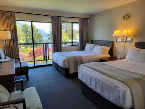 a hotel room with two beds and a balcony at Tofino Motel Harborview in Tofino